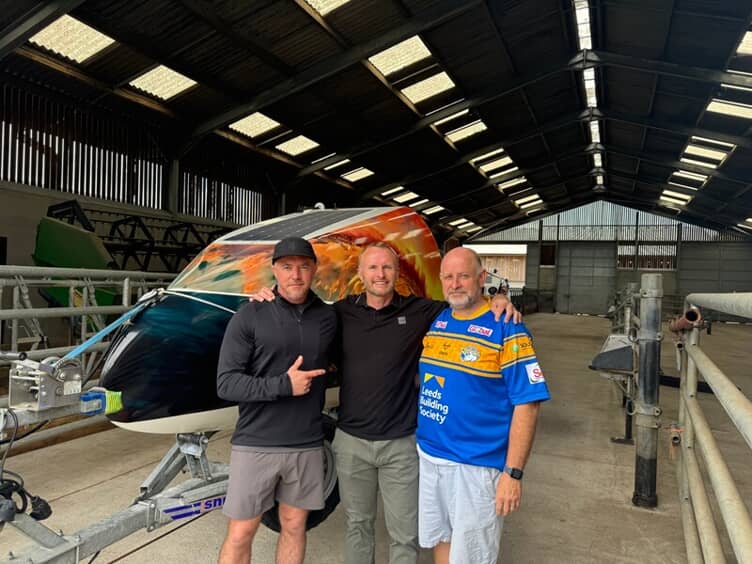 An image of the workers in front of the vinyl wrapped boat.